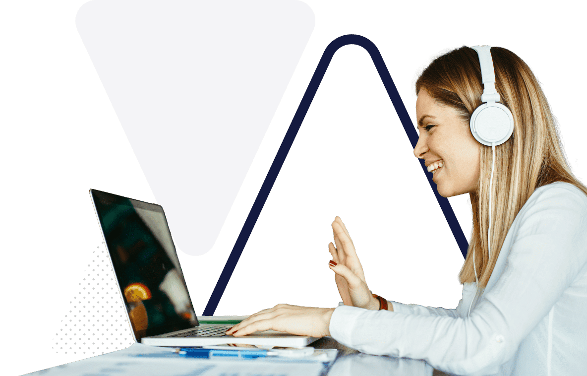 A woman saying hello to someone via a laptop and headset.