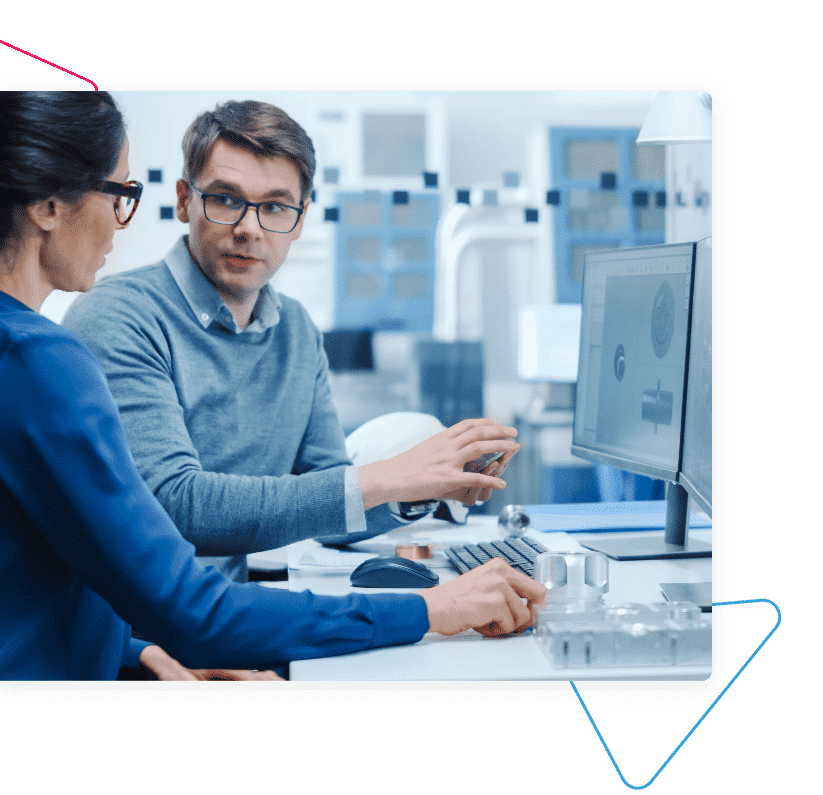 Two people sitting at a computer at a desk.