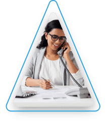 A woman sitting at a desk using a phone.