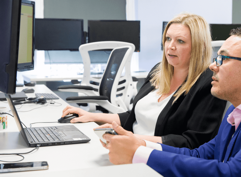 man and woman looking at computer screen