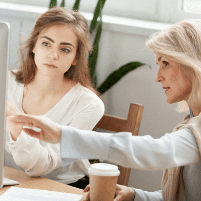 Two women sitting at a computer.