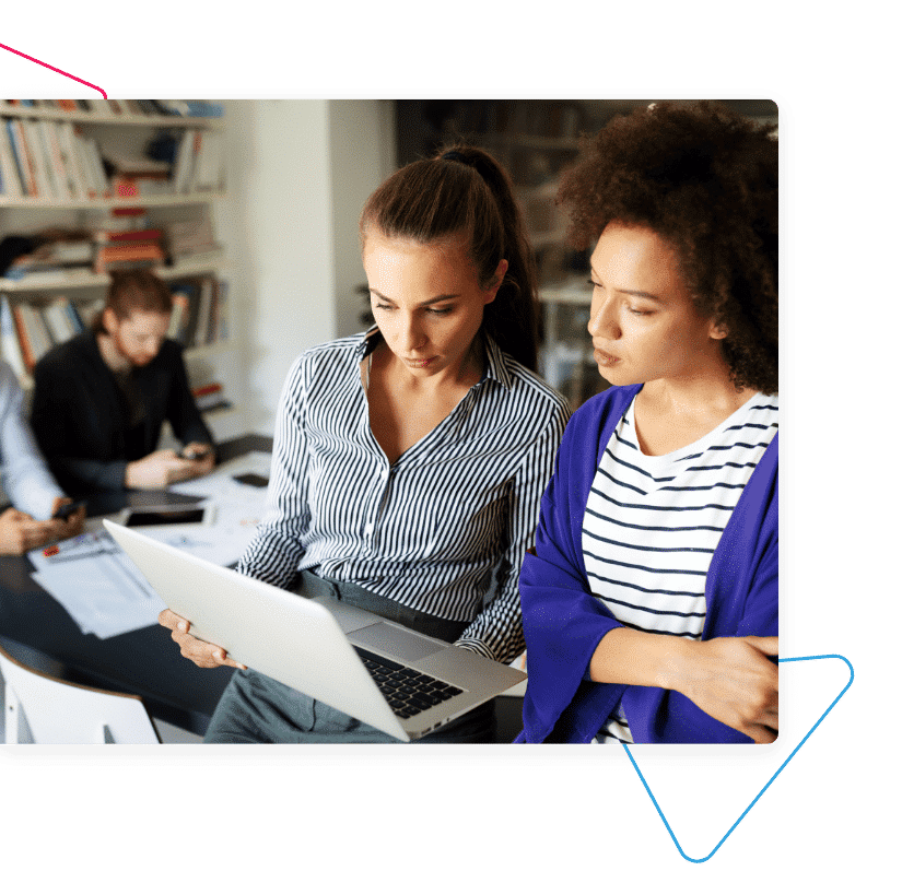 a woman showing another woman something on a laptop