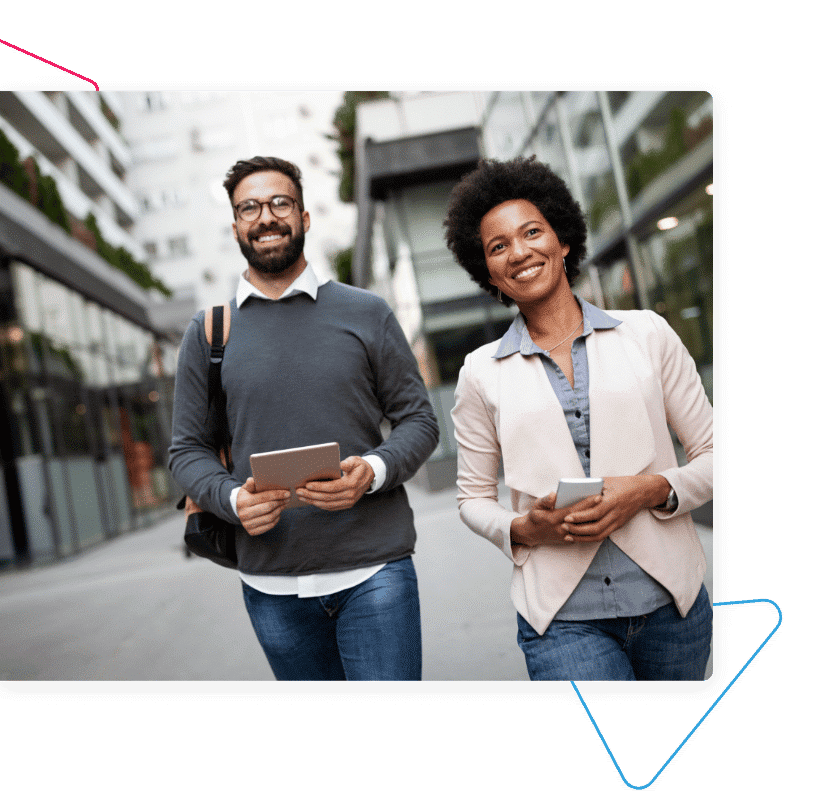 A woman holding a mobile phone and a man holding a tablet walking outside.