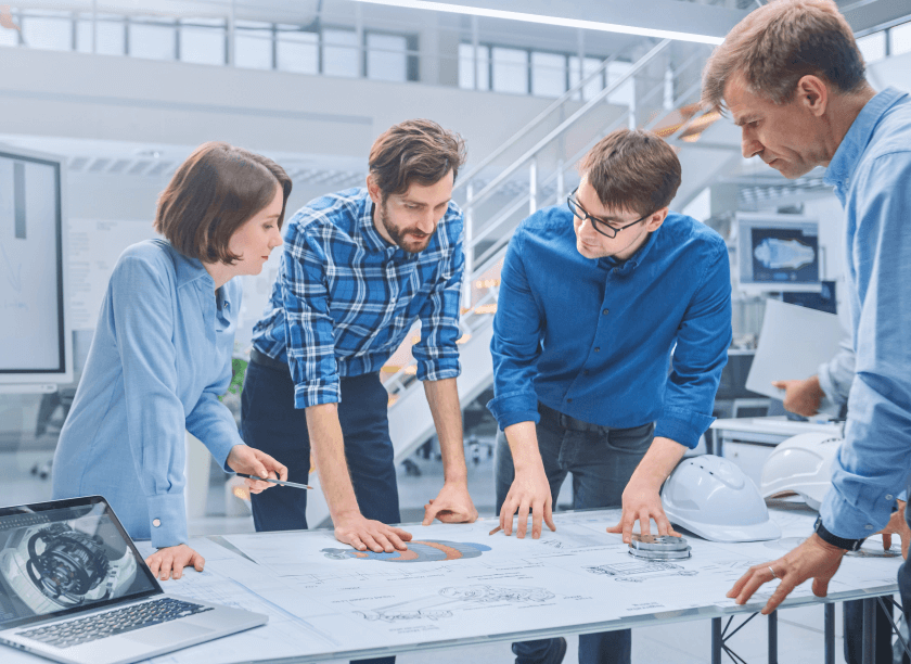 Four people standing around a desk.