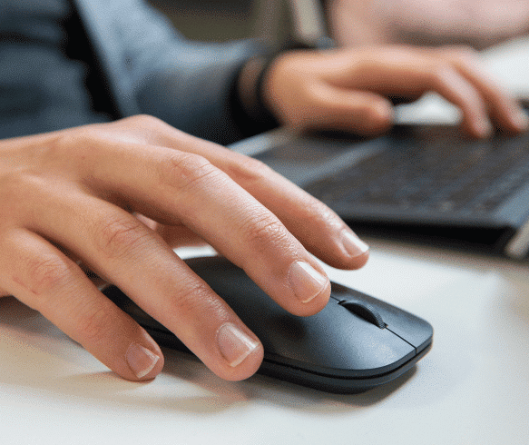 Person using a mouse and laptop keyboard.
