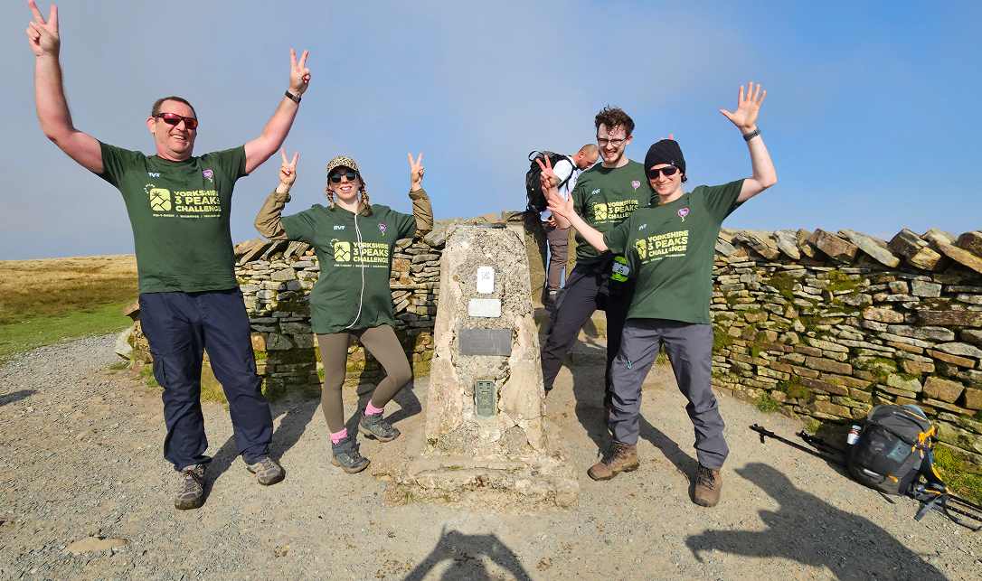 Four ITVET colleagues celebrating taking part in The Three Peaks and waving their arms