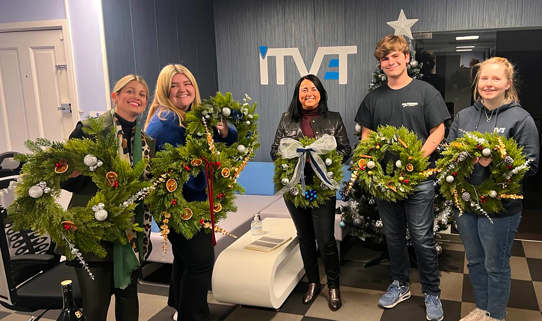 Five ITVET colleagues holding their handmade Christmas wreaths