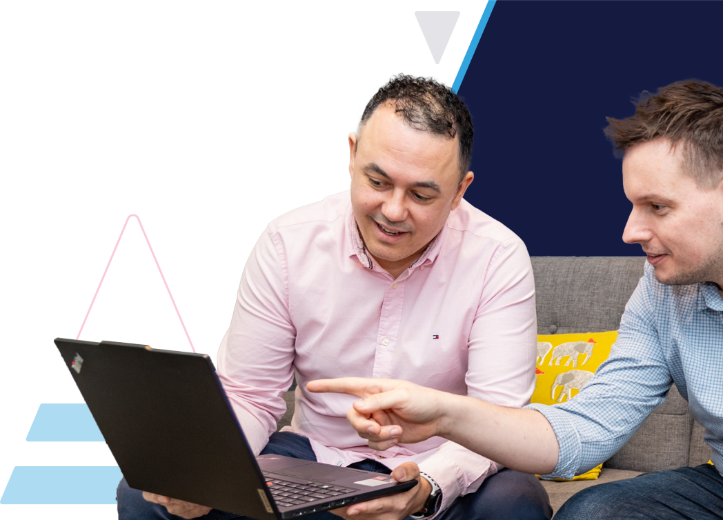 ITVET employees looking at laptop and pointing at the screen